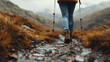 © ShinneProject - focus on shoes of cropping, people hiker in the mountains.Woman hiker ascends with trekking poles, showcasing the strength and resilience of outdoor enthusiasts.