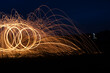 Abstract background of steel wool fireworks. Showers of glowing sparks from spinning steel wool. Steelwool in the night.