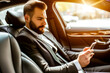 A suited businessman engages with a smartphone in the backseat of a luxury car, embodying corporate life