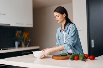 Wall Mural - Beautiful Women Cooking Healthy Salad in Domestic Kitchen, Smiling with Happiness