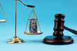 American Dollars on scales of justice, Gavel and block on blue background