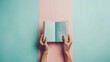 Hands holding an open book on pastel background. Reading, studying, school, diary, education, university learning, time for reading, morning pages, relaxation. Bookstore, library concept