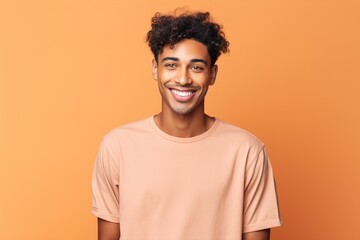 A man with a big smile on his face is wearing a pink shirt