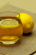 Tea with lemon in a glass mug. Macro. Poster for interior. A drink in the form of tea with lemon. Drops of water from hot tea on a mug.