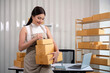 Woman asian in an online store check the customer address and package information on the laptop. Online shopping concept