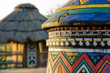 Fototapeta  - A traditional, colorful, round African hut of the Ndebele tribe in a peaceful South African village, bathed in the warm evening sunlight