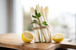 Standing bunch of fresh white asparagus. Seasonal spring vegetables with lemon and flat-leaf parsley on wooden cutting board. Kitchen scene for the seasonal gastronomy.