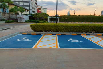 Car parking lot reserved for handicapped driver near supermarket or shopping mall. Car parking space for disabled people. Blue wheelchair sign marking on concrete parking area. Handicapped parking lot