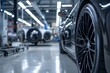Close-up of a black luxury car's wheel with more vehicles in the blurred background at a modern car showroom.