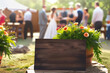 Rustic wooden wedding bridal party sign with blurred wedding background scene.