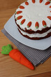 Homemade carrot cake with mascarpone cream cheese icing, mini marzipan carrot decorations and felt carrot