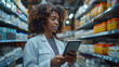 A female pharmacist walks between shelves with medicine in a pharmacy, holding a digital tablet in her hands. Copy space