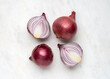 Red onion and cut in half sliced on white marble background top view