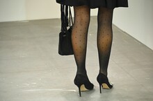 Close-up Shot Of Female Legs Wearing High Heels And Stockings On Gray Rough Concrete Floor