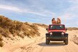 Couple With Friends On Vacation Driving Car On Road Trip Adventure To Beach With Women Standing