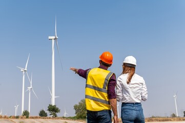 couple engineer team inspection check control wind power machine construction installation in wind energy factory. Two technician professional worker discussion for maintenance wind power turbine