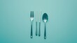 A minimalist arrangement of silverware on a pristine solid color tabletop