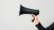 © Нина Башарова - A woman's hand holding a loudspeaker on a white background.