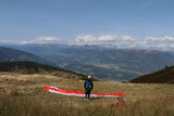 paraglider with open parachute looking at the panoramic view in the distance
