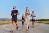 Fototapeta  - A group of friends maintains a healthy lifestyle by running outdoors on a sunny day, bonding over fitness and enjoying the energizing effects of exercise and nature