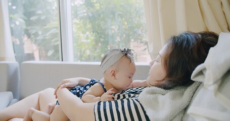 Poster - happy Asian family mother young woman holding adorable cute infant baby playing together with fun smile laugh face at home, motherhood love care childhood in life moment