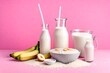 Tasty rice milk porridge with banana in white mask and milk in milkman on pink background with copyspace