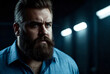 Portrait of brutal, bearded, aggressive, big person in blue shirt on dark background. Angry human bodyguard with stern look. Mafia man is ready to protect against violence and underground. Copy space