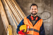 © Mediteraneo - Construction site manager standing  wearing safety vest and helmet, thinking at construction site. Young architect watching construction site with confidence.