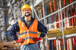© Mediteraneo - Construction site manager standing  wearing safety vest and helmet, thinking at construction site. Young architect watching construction site with confidence.