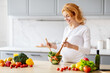 © Prostock-studio - Pregnant lady preparing salad at home