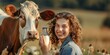 close up cow and smiling farmer woman holding a bottle of whole milk on a field in summer farm surroundings, farmer’s dairy produce concept, horizontal banner