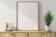 blank poster frame mockup on white wall living room with wooden sideboard with small green plant, 