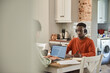 © mavoimages - Young multiracial couple working online from home in their kitchen