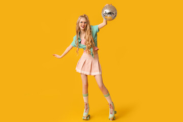 Wall Mural - Beautiful young happy woman in vintage roller skates with disco ball on yellow background