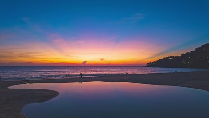 Wall Mural - Time lapse Beautiful sunset reflection in the beach puddle. The sun's rays glistened in the puddle, creating a mesmerizing dance of colors. stunning colorful reflection in sea surfect