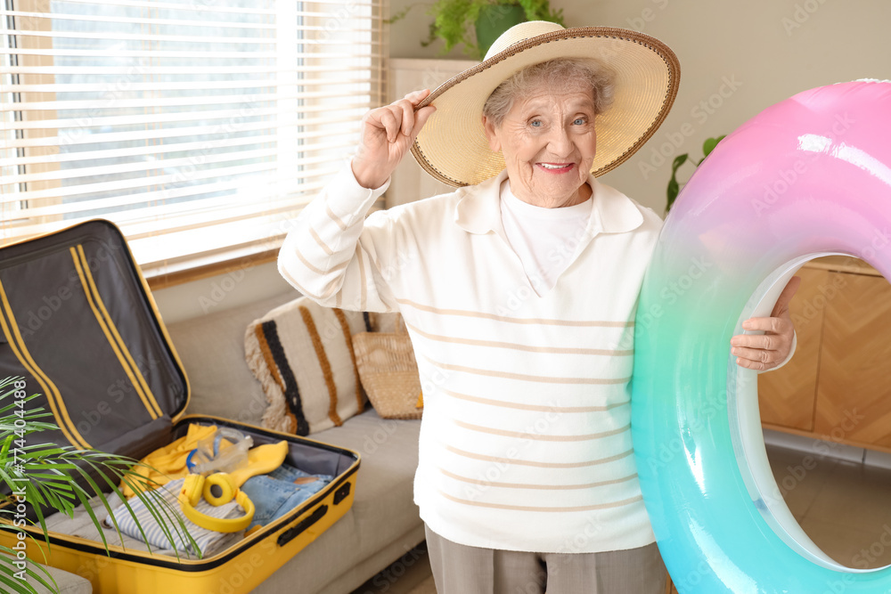 Senior female tourist with swim ring at home