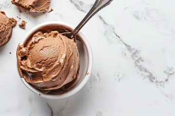 Wall Mural - Close up of chocolate mousse dessert on a spoon held by an African American hand against a white background