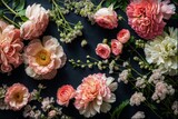 Fototapeta Tęcza - A flat lay photograph featuring pink and white peonies, ranunculus, chrysanthemums, with some leaves scattered around the flowers. The botanical backdrop has vibrant colors against a black background.