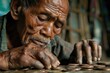 Elderly man carefully counting coins on a wooden table with intense focus