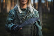 A military girl with a large kukri knife in her hand, soft focus photo.