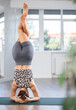Young woman practicing vinyasa yoga asanas on mat in fitness studio