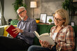 © Miljan Živković - mature senior couple man and woman husband and wife read book at home