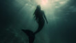 Authentic mermaid with the figure of a woman and the tail of a fish swimming ascending through sunlit waters, with her silhouette contrasting against the dark depths. Epic background for a wallpaper