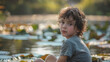 A boy sitting by a pond with lily pads in a park, his face filled with curiosity as he gazes at the camera.