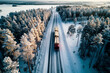Semi-Trailer logging truck driving down snowy road through wilderness