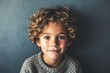 Portrait of a cute little boy with curly hair and blue eyes