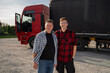 © phoenix021 - Father and son starting trucking company, satisfied trucker and fleet manager standing together