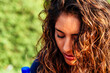 Thoughtful young woman with curly hair outdoors