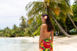 Tahiti luxury travel beach vacation woman walking in cover-up skirt on island, French Polynesia. Image is completely unretouched and model is without makeup. Authentic real people. Original Raw Image