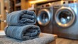   Two towels are stacked on top of one another in front of a washer and dryer in a laundry room